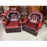 A Pair of Ox blood red Chesterfield style lounge chairs.