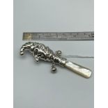 A Sterling silver Mr. Punch babies rattle with mother of pearl handle. [9.5cm length]
