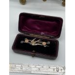 A Birmingham silver antique bar brooch designed with a swallow and two gold toned flowers. Comes