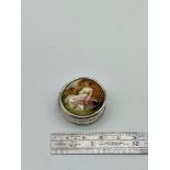 A 925 silver pill box with enamel lid depicting a semi nude figure.