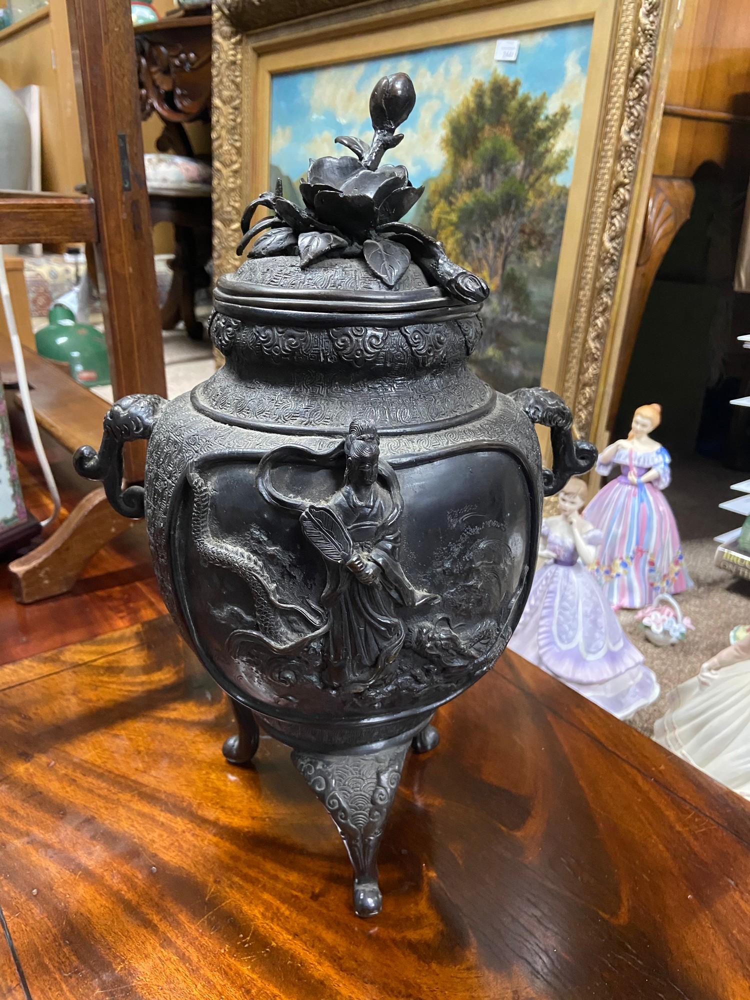 A 19th century large Chinese bronze incense burner pot, showing raised relief figures and designs.