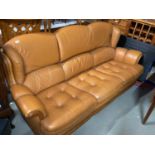 A Danish vintage light brown/ orange leather three seat sofa.