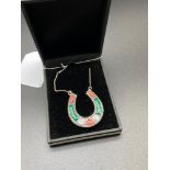 A Sterling silver lucky horse shoe pendant set with agate an malachite, Joined with a silver chain.