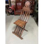 Antique Arabic folding campaign chair, designed with intricate carving and mother of pearl inlays.