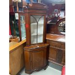 An Edwardian two section corner cabinet, designed with various line inlays.