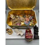 A Tin containing a collection of odds to include Buddha figures, jewellery and buttons.