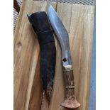 A Possible military Kukri knife with leather sheath. Designed with a wooden handle and brass mounts