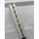 A Ladies 18k gold Diamond and Emerald bracelet. 0.64ct in total. [17 grams] [19cm in length]