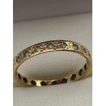 A Ladies 9ct gold band ring set with gem stones. [Ring size K] [2 Grams]