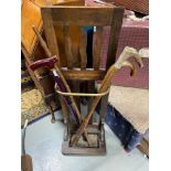 Antique stick stand designed with a gilt brass bar section, Contains four various walking sticks.