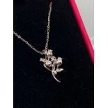 A 9ct white gold and diamond rose pendant and necklace. Pendant is designed with three diamonds