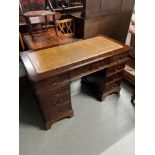 A Reproduction knee hole desk designed with a mustard leather top.