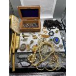 A Vintage red case containing a large quantity of vintage jewellery which includes necklaces,