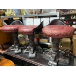 A Lot of three Indian Rose wood and red leather button top bar stools. Heavy single support bases.