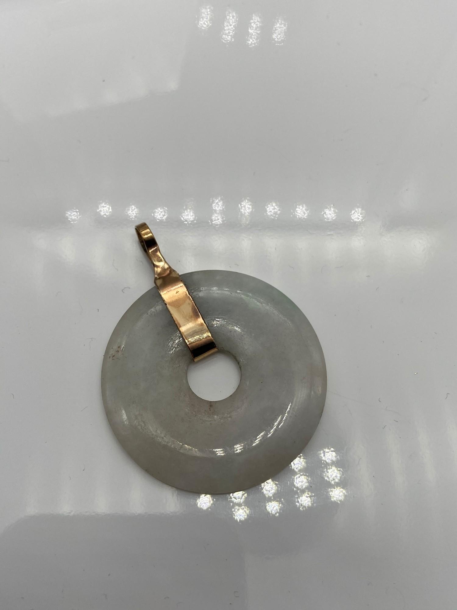 A Tested [14ct -15ct] gold and pale green jade pendant.