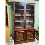 A Victorian two section bookcase. designed with two glass doors and adjustable shelving top.