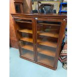 A Victorian mahogany two door bookcase. Designed with glass panel front doors and adjustable