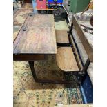An early 1900's oak and metal frame double school desk, designed with lift up chair area, lift up
