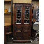 A c20th stained oak 2 section cabinet by Old Charm. 2 lead glazed doors above 2 smaller carved panel