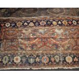 A large hand knotted Persian wool rug salmon pink ground with floral lozenge within a blue ground