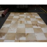 A large modern cream patchwork cowhide rug. Cream leather edged, 310cm x210cm