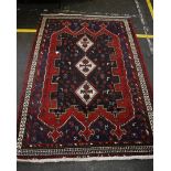 A large Afghan hand knotted wool rug, the geometric patterned central field with cream banded