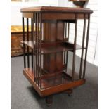 An Edwardian mahogany revolving two tier bookcase on Quadra form pedestal support.49cm x 49cm x