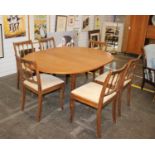 A 1960's teak circular extending dining table with intergral butterfly leaf & a set of five modern