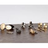 A collection of silver and yellow metal cuff links.