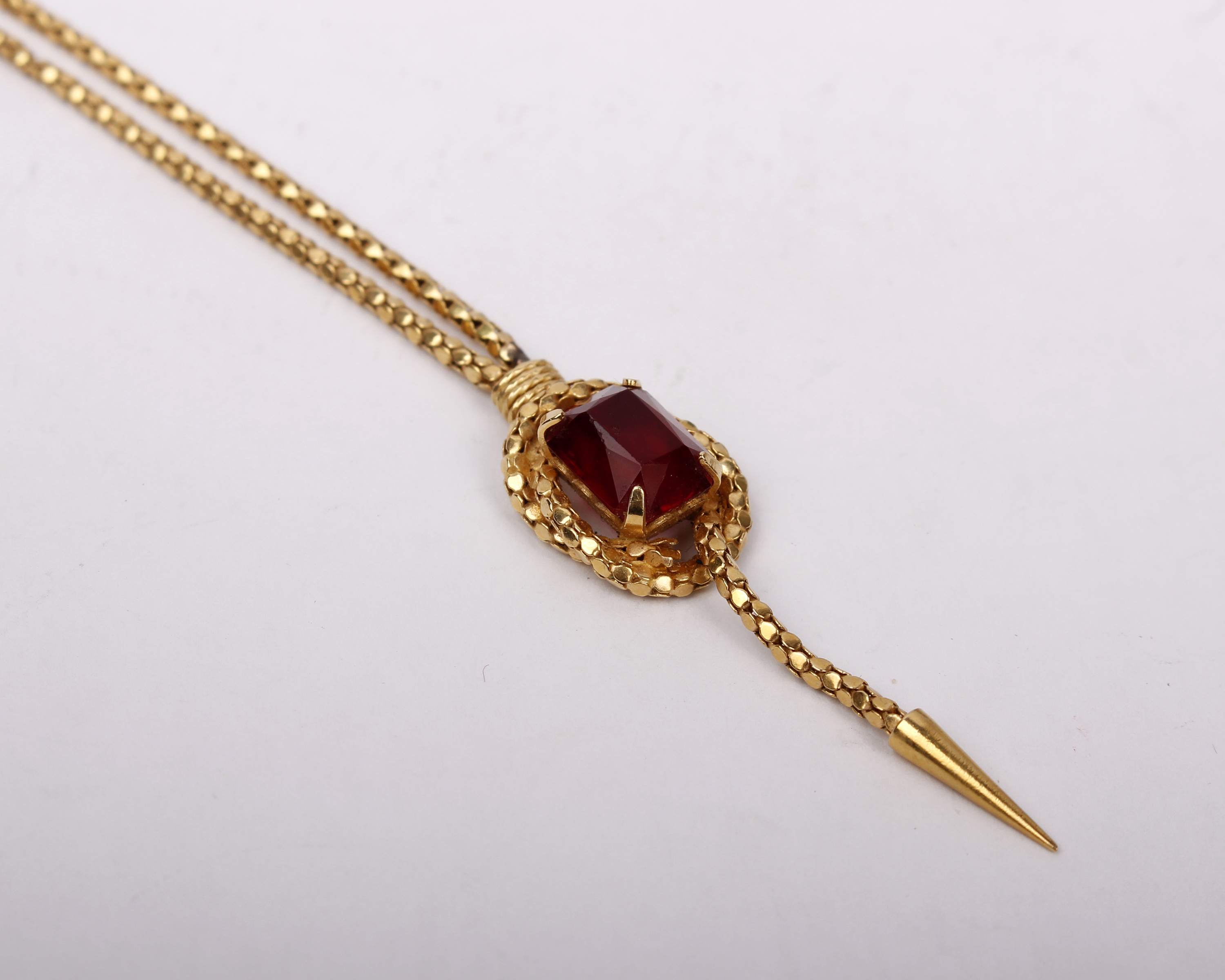 An 18ct gold pendant and chain, set with central synthetic emerald cut Ruby. 9.5g