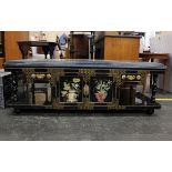 A 20th century Chinese black lacquered low table. The glass top enclosing a recessed hard stone