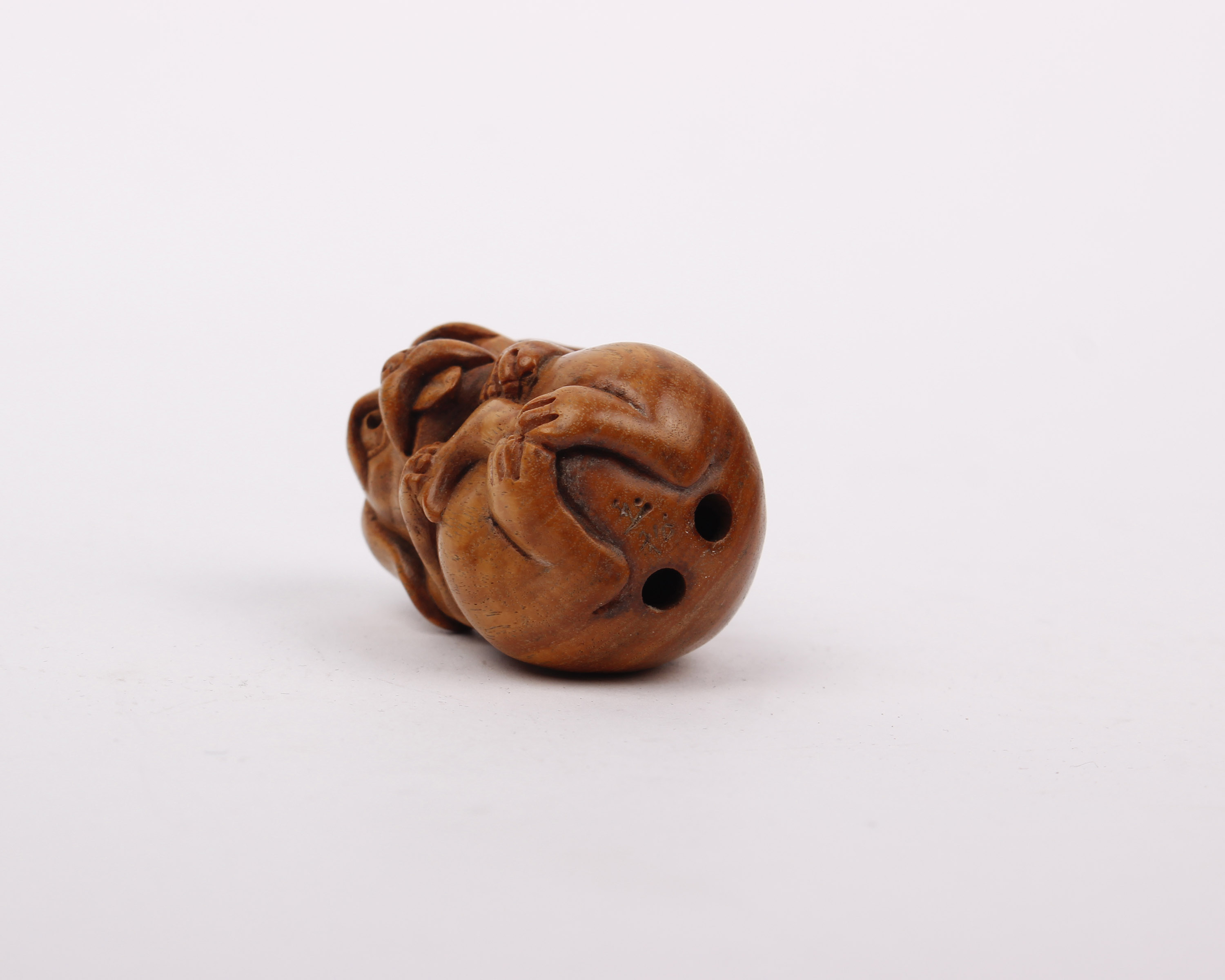 A small wooden carved Netsuke of a dog. - Image 2 of 2