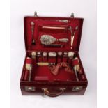 A red leather travelling vanity case with near complete interior containing fitted silver topped