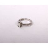 A platinum single stone diamond ring central emerald cut diamond 5.5mm x 4.5mm in a four claw corner