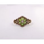 A 19th century unmarked yellow metal diamond and Peridot flower ring set with six round cut peridots