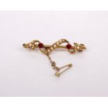 A 15ct gold ruby and split pearl bar brooch. 3.7g.