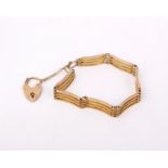 A 9ct gold gate link bracelet with 9ct heart locket. 15.4g