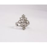 An 18k white gold and diamond open work navette shaped dress ring Set with nine clusters of round