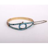 An unmarked white and yellow metal Victorian bangle bracelet set with cabochon turquoise (one