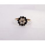 A 9ct gold sapphire and diamond flower ring. Six single cut diamond with a surround of round