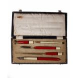 An early 20th century red and cream enamel desk set in fitted box, complete.