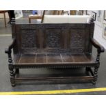 A part 17th century oak bench, the chip carved panel back married with a later 19th century