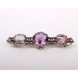 A white metal and amethyst brooch with seed pearl accents. 9g