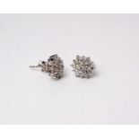 A pair of 18k white gold and diamond cluster earrings. Set throughout with round brilliant cut