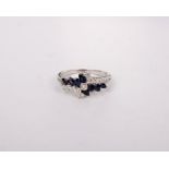 An 18k white gold sapphire and diamond ring set with marquis sapphires and brilliant cut diamonds.