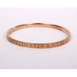 A 9ct gold bangle bracelet with bright cut decoration. 7.5g