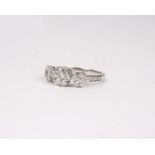 An 18k white gold and diamond ring. Set with three clusters of seven round brilliant cut diamonds