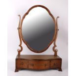 A 19th century mahogany dressing mirror. The shield mirror over serpentine front box base, fitted