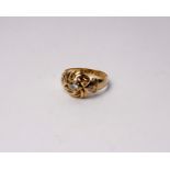 An 18ct gold and diamond knot ring set with central brilliant cut diamond with star set single cut