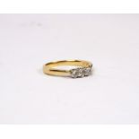 An 18ct gold three stone diamond ring. Three brilliant cut diamonds in an openwork setting. Size N